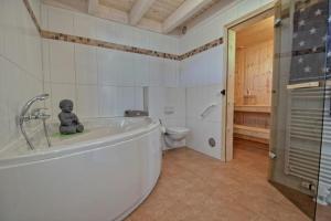 a teddy bear sitting on top of a bath tub in a bathroom at Ferienhaus Luan in Nordhorn