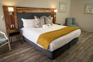 a hotel room with a large bed and a chair at CedarWoods of Sandton in Sandton