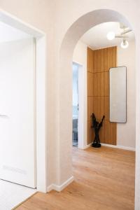 an archway leads into a room with a wooden wall at Suite Home Reichenhall in Bad Reichenhall