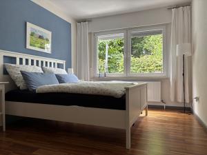 a bedroom with a white bed and a window at Dorle`s Huus in Nordhorn