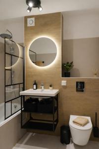 a bathroom with a sink and a toilet and a mirror at Suite Home Reichenhall in Bad Reichenhall