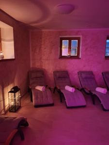 a waiting room with purple chairs and a window at Penzion Pupík in Modrava