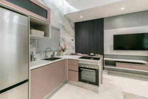 a kitchen with a sink and a stove and a tv at Ditsametse Luxe Suites in Gaborone +51 photos