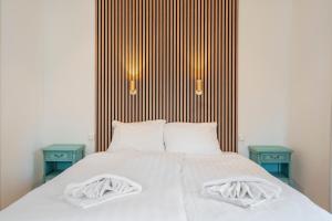 a bed with two pillows and two blue tables at Studio Oak & Studio Linde in Aerdenhout