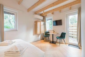 a bedroom with a bed and a table and two chairs at Studio Oak & Studio Linde in Aerdenhout