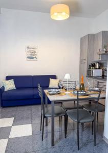 a living room with a table and a blue couch at APPARTAMENTI TRA CIELO E MARE in Piombino