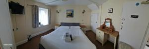 a bedroom with a white bed and a television at Trehellas House Hotel & Courthouse restaurant in Bodmin