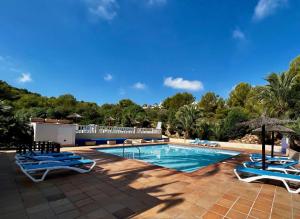 a swimming pool with lounge chairs and a resort at Bellaluz 18-16 La Manga Club in Atamaría