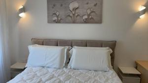 a bed with two pillows and a picture on the wall at Tourgo Venice in Mestre