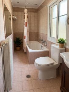 a bathroom with a toilet and a tub and a sink at Aegli Hotel in Perama +43 photos