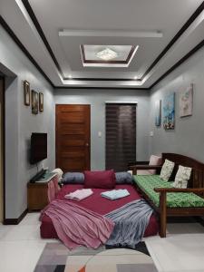 a bedroom with a bed and a tv in it at Aquino Stays in Luna
