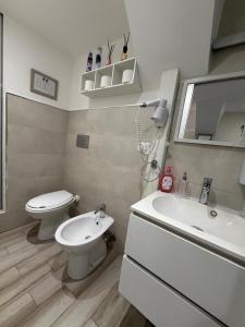 a white bathroom with a toilet and a sink at Spataro Home in Catania +31 photos