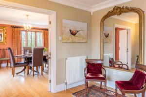a dining room with a table and a mirror at Tuffon Hall Farmhouse 10 in Sible Hedingham