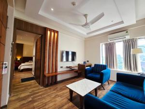 a living room with a blue couch and a table at Hotel Akashdeep in Kolkata