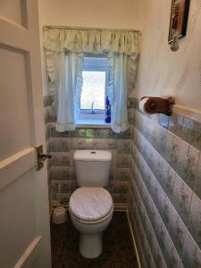 a small bathroom with a toilet and a window at Teesside Haven in Middlesbrough in Middlesbrough