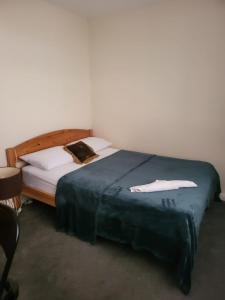 a bedroom with a bed with a blue blanket and white pillows at Teesside Haven in Middlesbrough in Middlesbrough