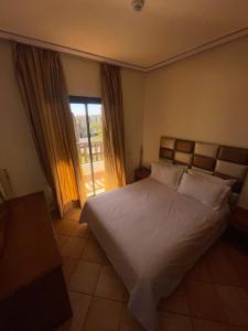 a bedroom with a large white bed and a window at Hotel Residence Rihab in Agadir +35 photos