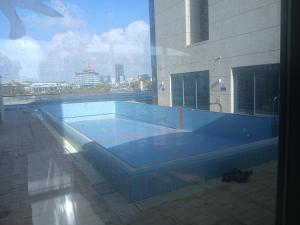 a large blue swimming pool in a building at מרינה טוורס מלון בוטיק in Herzliya B +31 photos