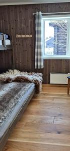 a bedroom with a bed and a window and a floor at Flat With Lake View In Sjusjøen in Sjusjøen