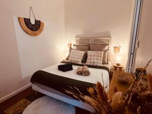 a bedroom with a bed with two slippers on it at Le Petit Millésime - Homillesime in Dijon