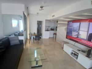 a living room with a large flat screen tv at מרינה טוורס מלון בוטיק in Herzliya B