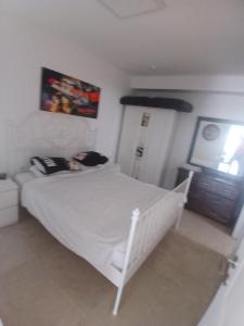 a bedroom with a white bed and a television at מרינה טוורס מלון בוטיק in Herzliya B