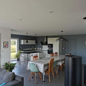 a kitchen and dining room with a table and chairs at La Belle Vue Piscine chauffée et abritée, vue sur l'océan, plage à pied, bord de mer, BRETAGNE LBC in Clohars-Carnoët