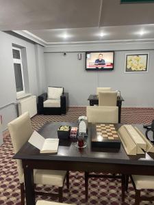 a living room with a table with chairs and a television at zirve otel in Kumbet