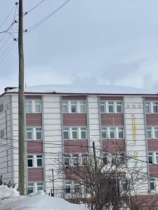 an apartment building with snow in front of it at zirve otel in Kumbet