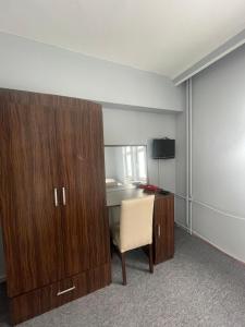a room with a desk and a cabinet and a chair at zirve otel in Kumbet