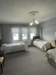 a bedroom with two beds and two windows at zirve otel in Kumbet