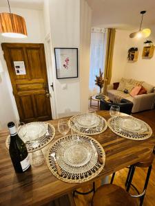 a wooden table with glasses and a bottle of wine at Le Petit Millésime - Homillesime in Dijon