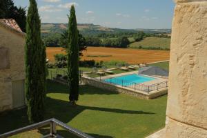 an external view of a villa with a swimming pool and trees at Plates Luxury Farm House Chambres d'hôtes et gîte in Saint-Mézard