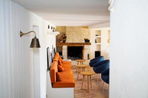 a living room with couches and chairs and a fireplace at Plates Luxury Farm House Chambres d'hôtes et gîte in Saint-Mézard
