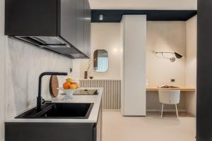 a kitchen with a sink and a bowl of fruit on the counter at Magnolia Studio Appartamento Marina di Carrara in Marina di Carrara +17 photos