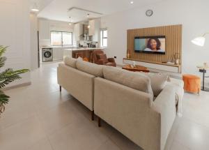 a living room with two couches and a tv at Elle Apartments in Lusaka