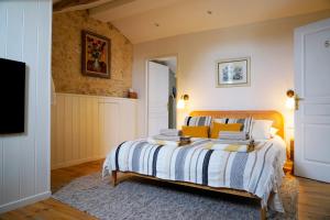a bedroom with a bed with yellow and white sheets at Plates Luxury Farm House Chambres d'hôtes et gîte in Saint-Mézard +51 photos