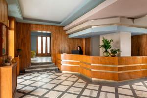 Eine Lobby mit einer Frau, die an einem Schreibtisch sitzt. in der Unterkunft Hotel Milani in Rom