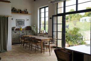 a dining room with a wooden table and chairs at Plates Luxury Farm House Chambres d'hôtes et gîte in Saint-Mézard