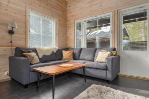 a living room with a couch and a table at Skicamp 3 - Modern 3BR Villa in Pyhätunturi in Pyhätunturi