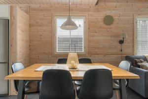 a dining room with a wooden table and chairs at Skicamp 3 - Modern 3BR Villa in Pyhätunturi in Pyhätunturi +32 photos