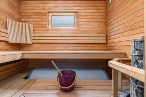 a sauna with a bucket in the middle at Skicamp 3 - Modern 3BR Villa in Pyhätunturi in Pyhätunturi