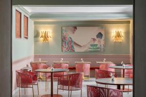 ein Esszimmer mit Tischen und roten Stühlen in der Unterkunft Hotel Milani in Rom
