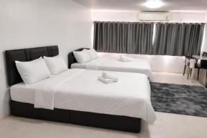 two beds in a hotel room with towels on them at popular condo c5 แม่ตัง in Thung Si Kan