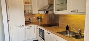 a kitchen with white cabinets and a sink at Vakantiehuis Vinkeveen in Vinkeveen