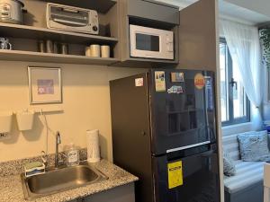 a small kitchen with a sink and a refrigerator at holiday with a maid in Sampong