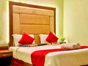 a bedroom with a large bed with red pillows at The Bay Leaf Resort in Shimla