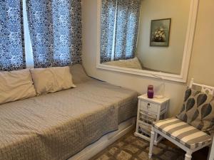 a bedroom with a bed and a mirror and a chair at holiday with a maid in Sampong