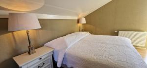 a bedroom with a white bed and a lamp on a dresser at Vakantiehuis Vinkeveen in Vinkeveen