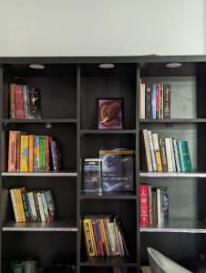 a book shelf filled with lots of books at Tayra - The Glass Villa in Somvārpet